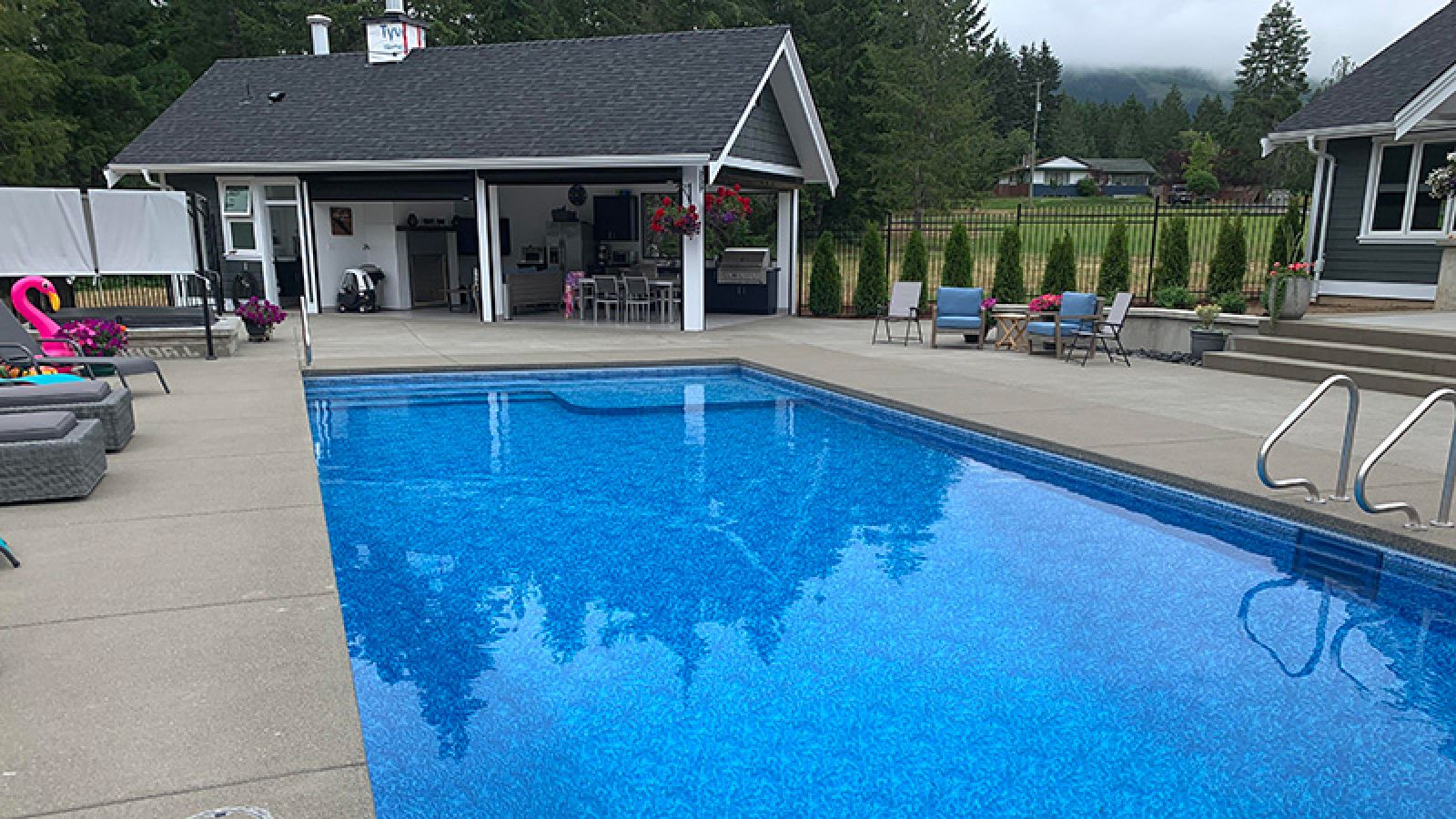 Rectangle pool with home  and forest in behind